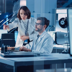 2 persons in a lab discussing in front of computer screens