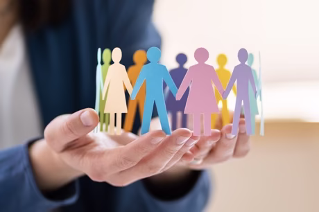 Hands holding paper figures in different colors